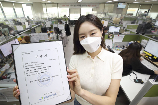 서울 동작구에 위치한 KT 콜센터에서 모델이 KT AICC의 클라우드 보안 인증서를 보여주고 있다. KT 제공